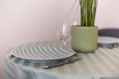 a table with a plate and a knife and a glass at Hypercentre - Proche Parking Gratuit - Fibre - Calme in Narbonne
