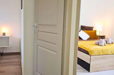 a door leading to a bedroom with a bed at L'Orchidée, proche de la gare avec clim et terrasse in Narbonne
