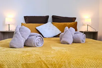 a bed with towels and pillows on it at L'Orchidée, proche de la gare avec clim et terrasse in Narbonne