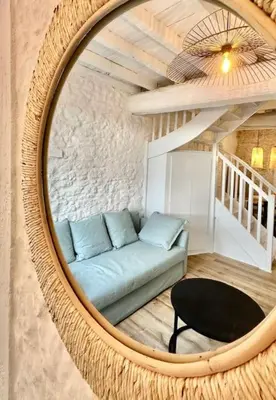 a couch in a living room with a mirror at Pierre Lauragaise in Avignonet-de-Lauragais