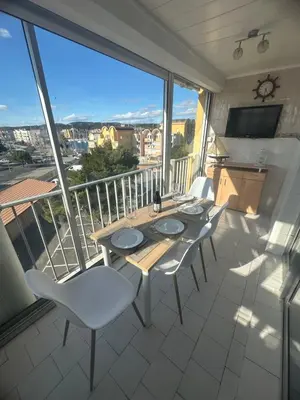 a table and chairs on a balcony with a view at Superbe 2 pièces climatisé avec piscines in Gruissan