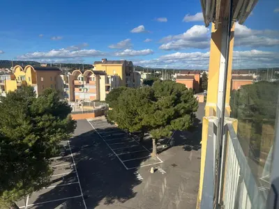 a view of a parking lot with trees and buildings at Superbe 2 pièces climatisé avec piscines in Gruissan