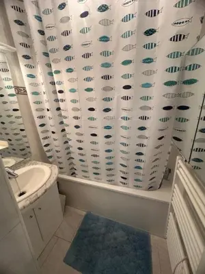 a bathroom with a toilet and a shower curtain at Superbe 2 pièces climatisé avec piscines in Gruissan
