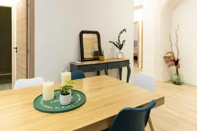a dining room with a table and a mirror at Olivier ATTON in Narbonne