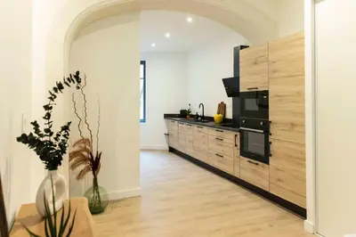 a kitchen with wooden cabinets and a black appliances at Olivier ATTON in Narbonne