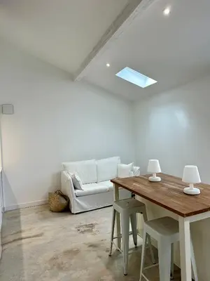 a living room with a white couch and a table at Maison Jasmin in Gruissan