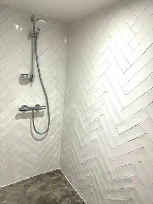 a bathroom with a shower with white tiles at Maison Jasmin in Gruissan