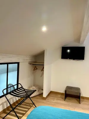 a bedroom with a bunk bed and a tv on the wall at Maison Jasmin in Gruissan