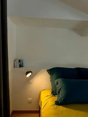 a bed with two pillows on it in a room at Maison Jasmin in Gruissan
