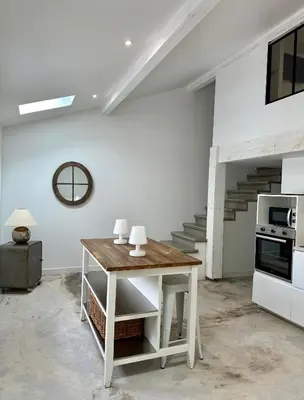 a kitchen with a wooden table in a room at Maison Jasmin in Gruissan