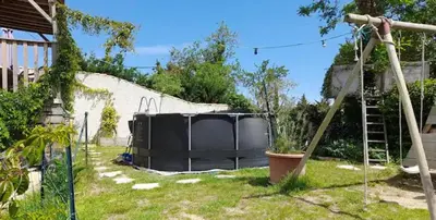 a garden with a black object in the grass at Roquevaquiere - Ancienne Grange rénovée - Logement autonome in Ouveillan