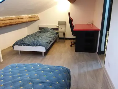 a room with a bed and a desk and a red table at Roquevaquiere - Ancienne Grange rénovée - Logement autonome in Ouveillan