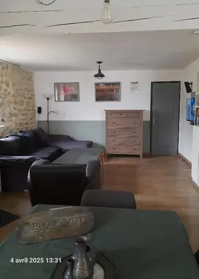 a living room with a couch and a table at Roquevaquiere - Ancienne Grange rénovée - Logement autonome in Ouveillan