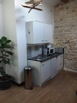 a kitchen with white cabinets and a counter top at Roquevaquiere - Ancienne Grange rénovée - Logement autonome in Ouveillan