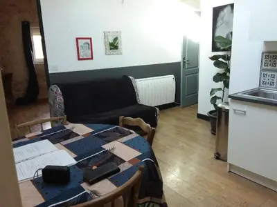 a living room with a table and a couch at Roquevaquiere - Ancienne Grange rénovée - Logement autonome in Ouveillan