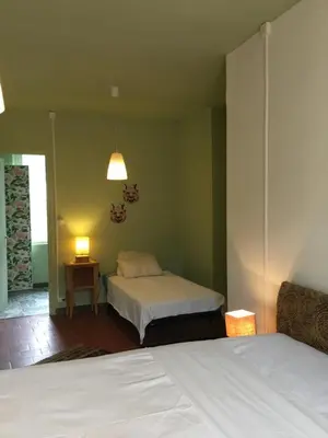 a bedroom with two beds and a table with a lamp at La 21 avenue des Corbières in Durban-Corbières