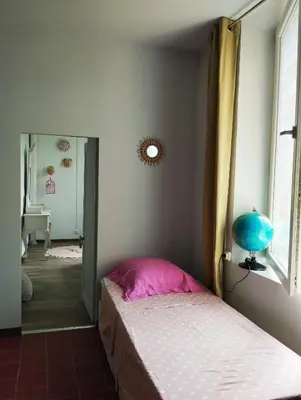 a bedroom with a bed and a window at La 21 avenue des Corbières in Durban-Corbières