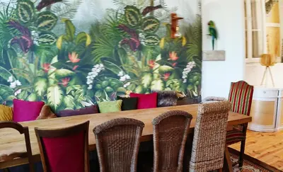 a dining room with a wooden table with chairs at La 21 avenue des Corbières in Durban-Corbières