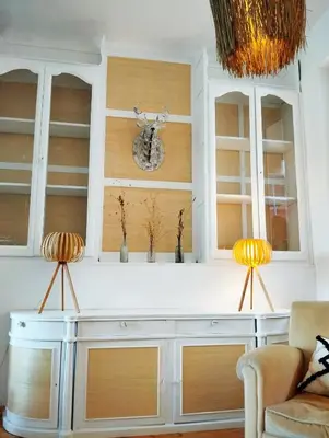 a white hutch with two chairs in a living room at La 21 avenue des Corbières in Durban-Corbières