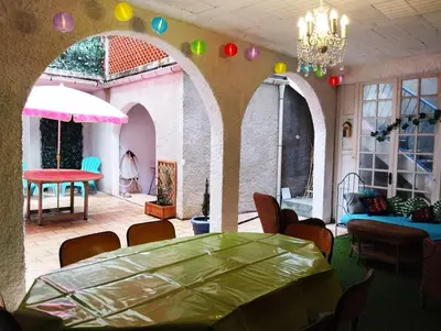 a room with a table and chairs and a chandelier at La 21 avenue des Corbières in Durban-Corbières