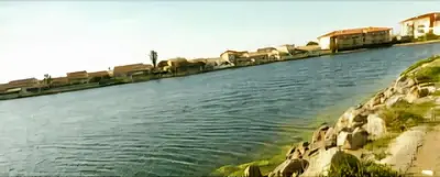 a large body of water with houses on the shore at Mimi in Port-la-Nouvelle
