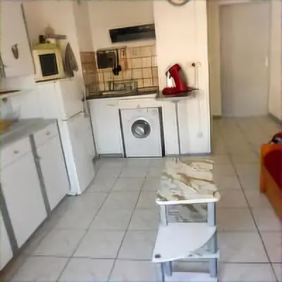 a small kitchen with a washing machine and a table at Mimi in Port-la-Nouvelle