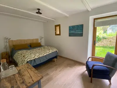 a bedroom with a bed and a table and a chair at Villa Kiener in Villeneuve-la-Comptal