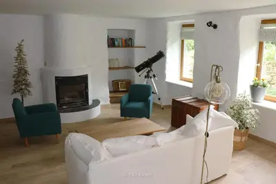 a living room with a white couch and a fireplace at Villa Kiener in Villeneuve-la-Comptal