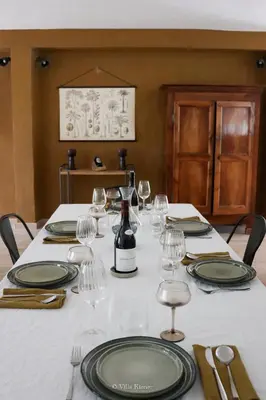 a table with glasses and a bottle of wine on it at Villa Kiener in Villeneuve-la-Comptal