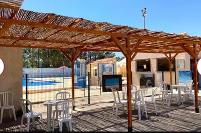 a table and chairs under a wooden pergola at Evasion en Occitanie in Mailhac