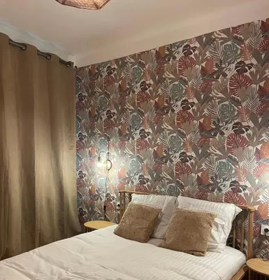 a bedroom with a bed with a floral wallpaper at Evasion en Occitanie in Mailhac