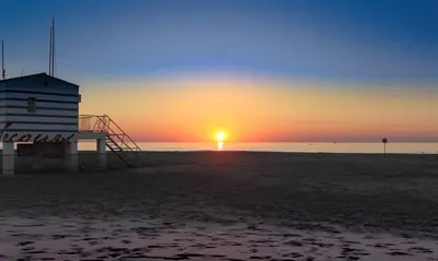 a sunset on the beach with a life guard station at Evasion en Occitanie in Mailhac