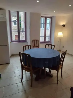 a dining room with a blue table and chairs at Charmante maison de village cessenon sur Orb in Cessenon