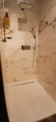 a bathroom with a shower in a marble wall at Occit'Homières in Saint-Pons