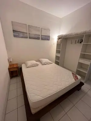 a bedroom with a bed and shelves in it at Appartement port GRUISSAN in Gruissan