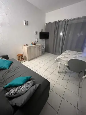 a bedroom with a bed and a table and a table and chair at Appartement port GRUISSAN in Gruissan