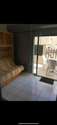 a bedroom with a bed and a view of a patio at Appartement port GRUISSAN in Gruissan