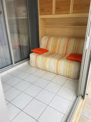 a small room with a couch on a tiled floor at Appartement port GRUISSAN in Gruissan