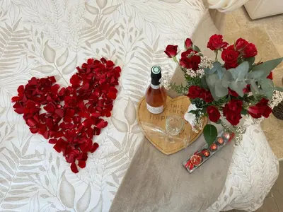 a bouquet of red roses in a vase and a heart at l'Idylle - Coeur de Bastide - balnéo - Clim in Carcassonne