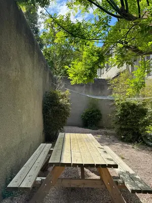 a wooden bench sitting next to a wall at l'Idylle - Coeur de Bastide - balnéo - Clim in Carcassonne