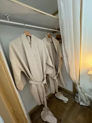 a closet with coats and shoes and a curtain at l'Idylle - Coeur de Bastide - balnéo - Clim in Carcassonne