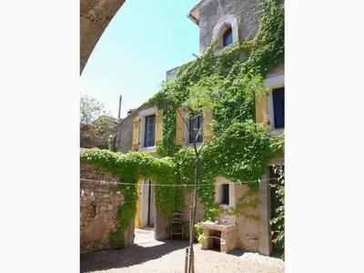 a house with ivy on the side of it at Lo Cantou Comfortable holiday residence in Camplong-dʼAude