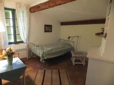 a bedroom with a bed in the corner of a room at Lo Cantou Comfortable holiday residence in Camplong-dʼAude
