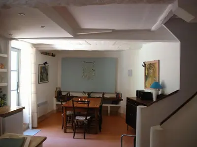a living room with a table and a dining room at Lo Cantou Comfortable holiday residence in Camplong-dʼAude
