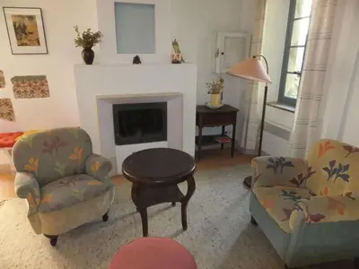 a living room with two chairs and a fireplace at Lo Cantou Comfortable holiday residence in Camplong-dʼAude