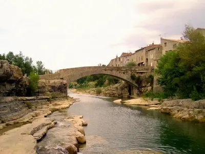 a bridge over a river in a city at Lo Cantou Comfortable holiday residence in Camplong-dʼAude