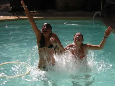 two people are playing in a swimming pool at 