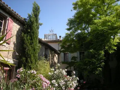 an old house with trees and flowers in front of it at 