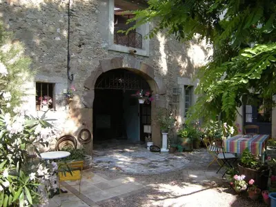 an entrance to a stone building with a table and chairs at 