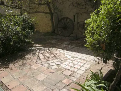 a brick walkway with a wheel in a garden at 